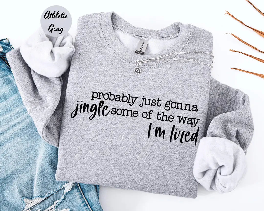 Athletic Gray crewneck sweatshirt with script lettering that reads probably just gonna jingle some of the way I'm tired, flat lay view.