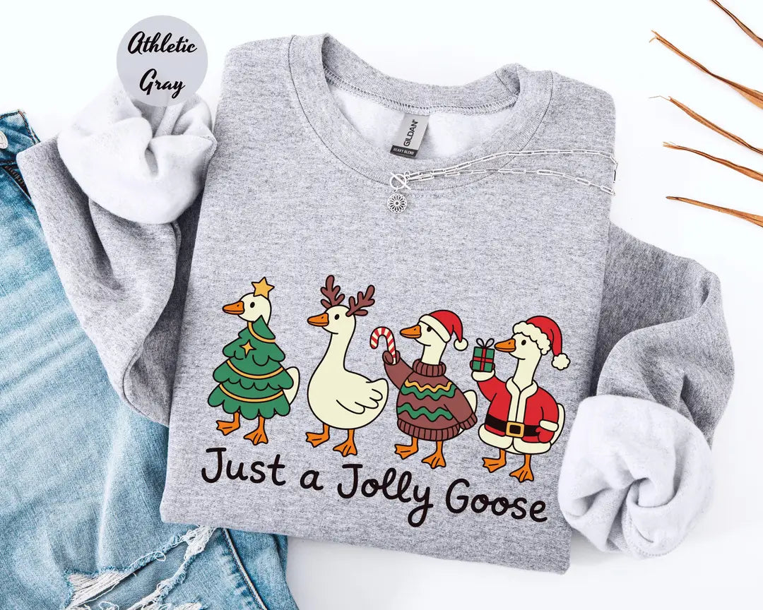 Athletic Gray crewneck sweatshirt with geese dressed as a Christmas tree, reindeer and Santa above the words just a jolly goose, flat lay view.