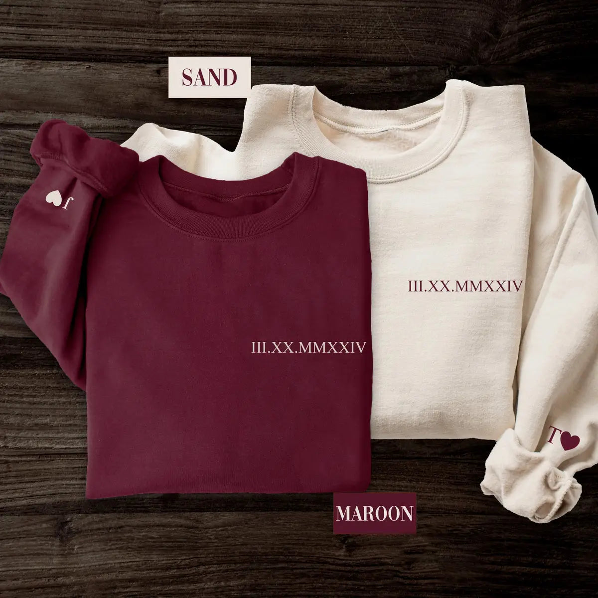 Crewneck sweatshirts in two colors showing a custom date in Roman numerals on the chest and an initial with a heart on the cuff.