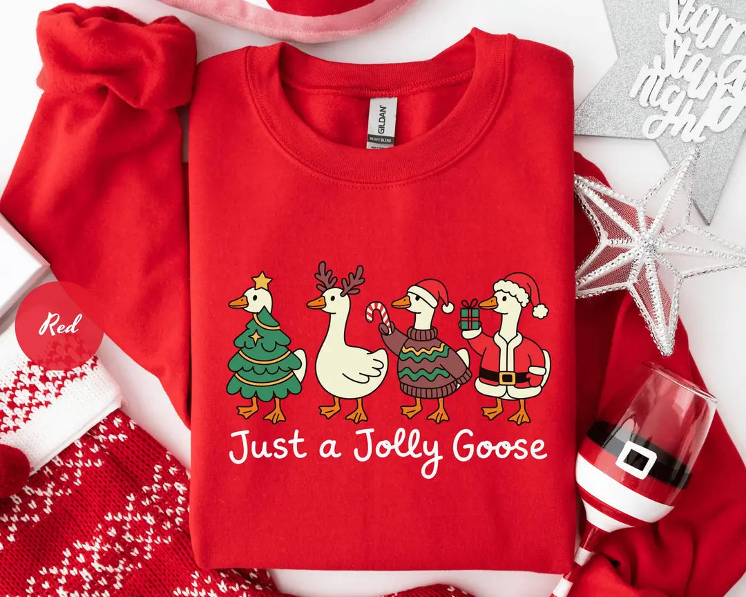 Red GD crewneck sweatshirt with geese dressed as a Christmas tree, reindeer and Santa above the words just a jolly goose, flat lay view.