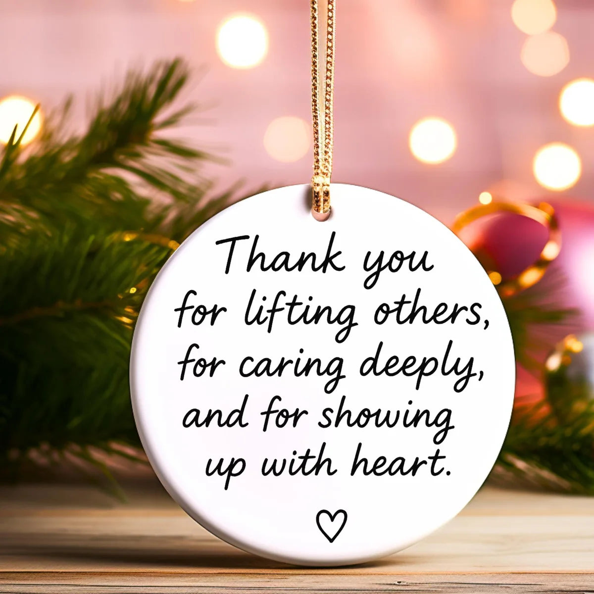 Alternate view of a round ceramic ornament with the visible Showing Up With Heart message.