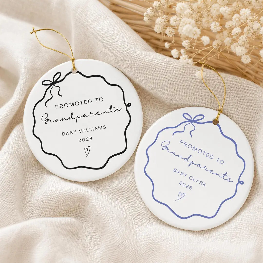 Black and blue wavy bow frame round ceramic Promoted to Grandparents ornaments with a personalized name and year on cream cloth