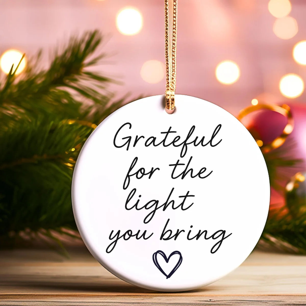 Alternate view of a round ceramic ornament with the visible Grateful for the Light You Bring message.