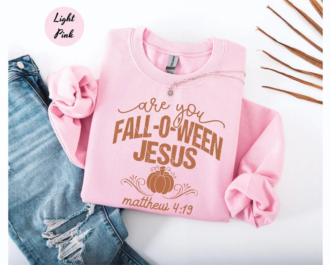 Light Pink crewneck sweatshirt with printed a pumpkin with the words are you fall-o-ween jesus and matthew 4:19, flat lay view.