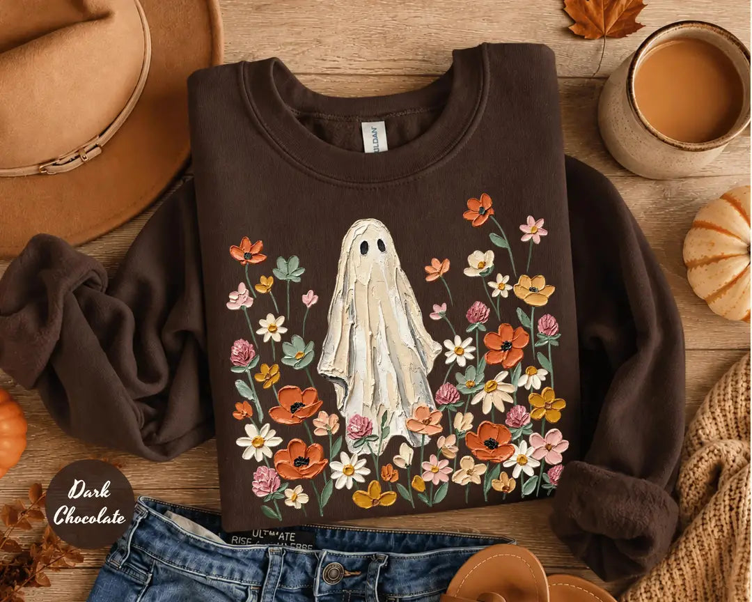 Dark Chocolate crewneck sweatshirt with printed a ghost standing in a field of autumn wildflowers, flat lay view.