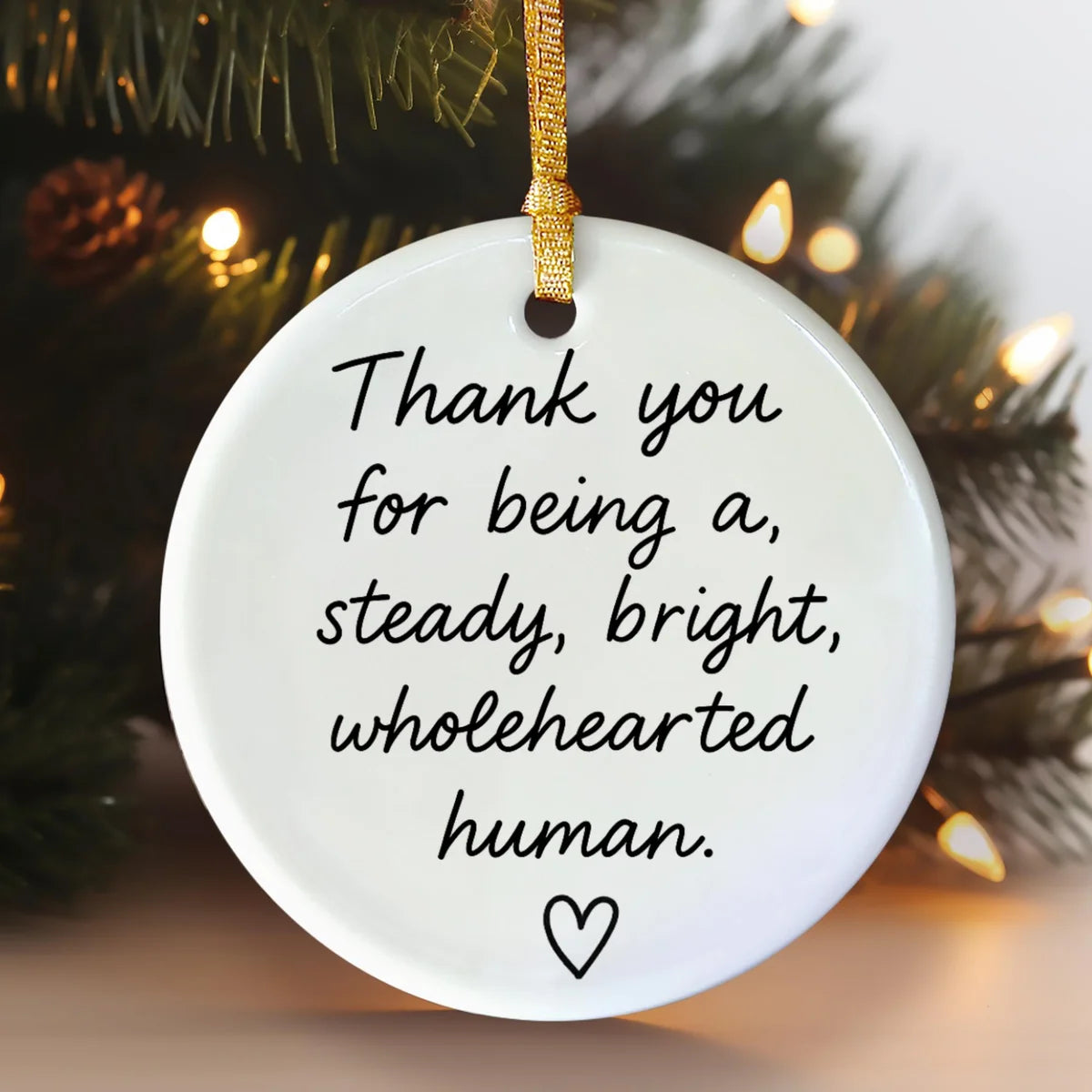 Alternate view of a round ceramic ornament with the visible Steady Bright Wholehearted message.
