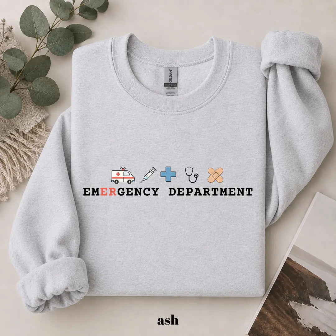Ash crewneck sweatshirt with printed an ambulance, syringe, cross, stethoscope and bandage above the words emergency department, flat lay view.
