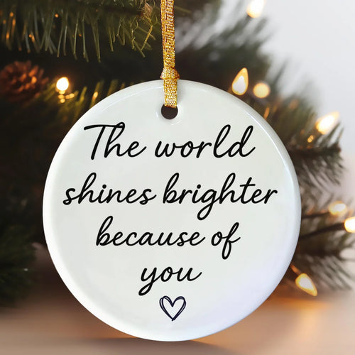 Alternate view of a round ceramic ornament with the visible The World Shines Brighter Because of You message.