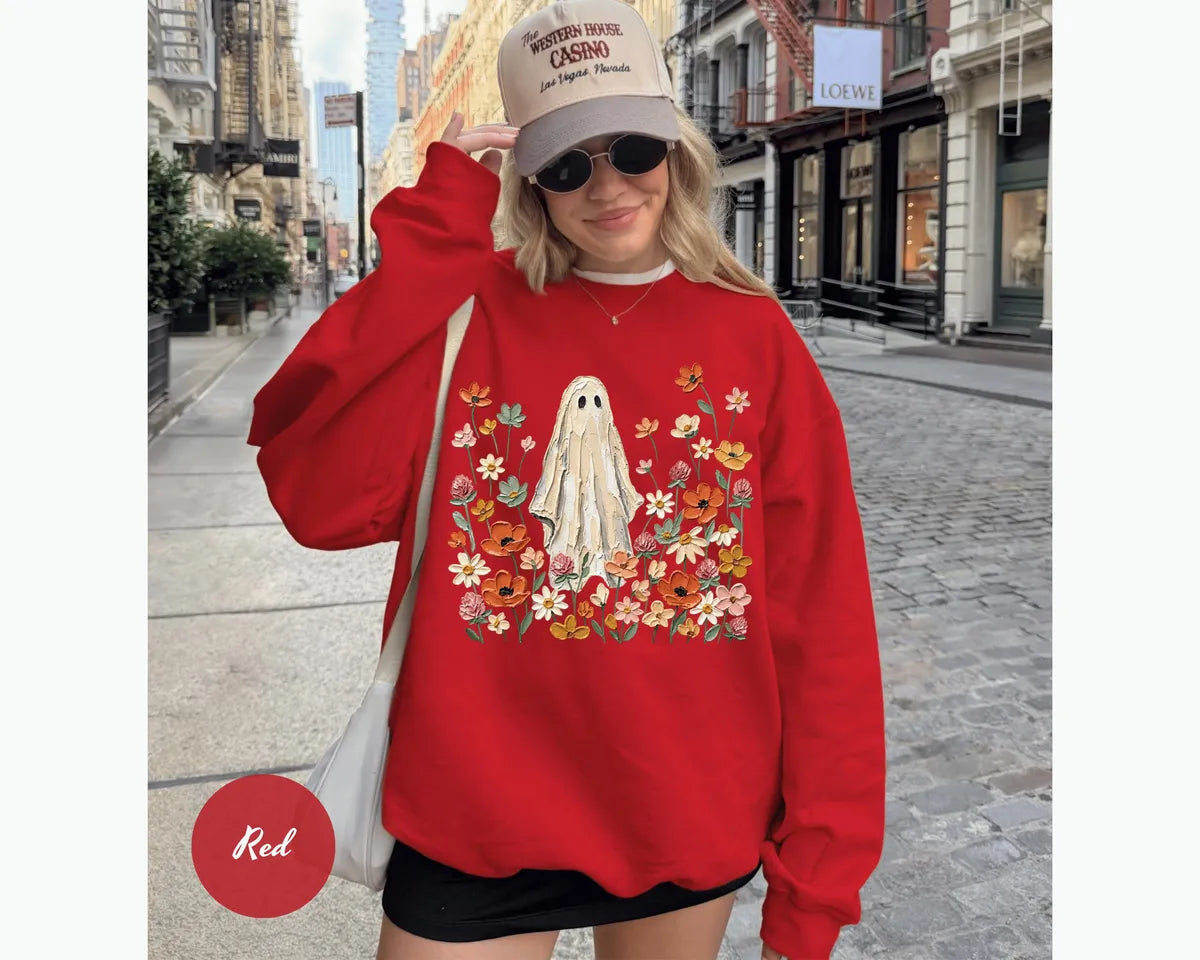 Red GD crewneck sweatshirt with printed a ghost standing in a field of autumn wildflowers, worn by a model.