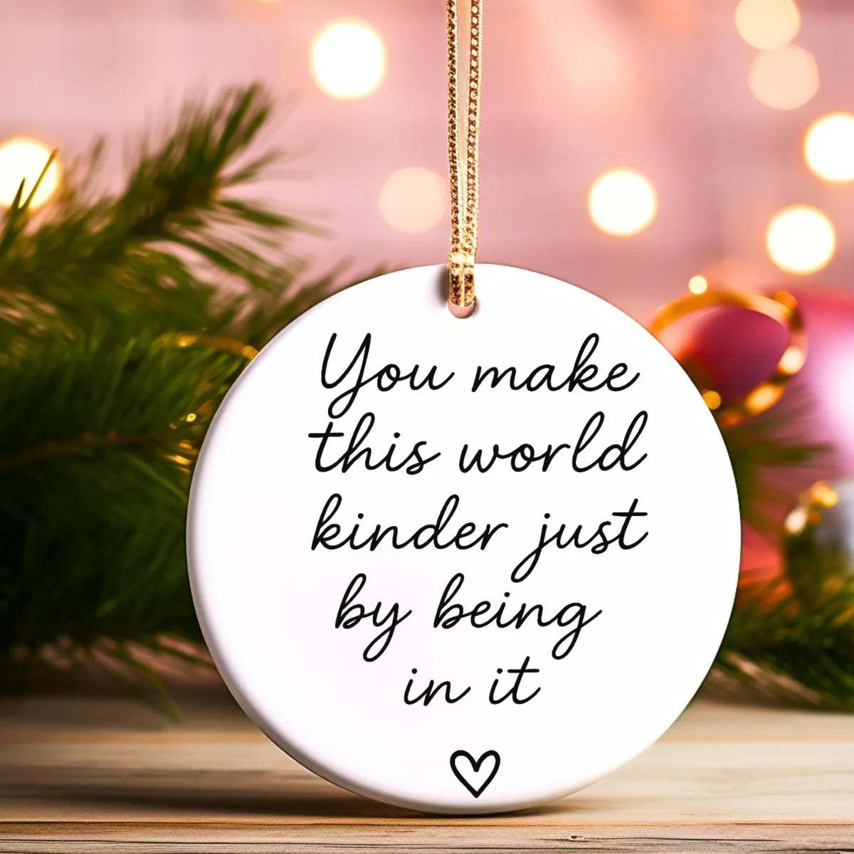 Alternate view of a round ceramic ornament with the visible You Make This World Kinder Just by Being in It message.