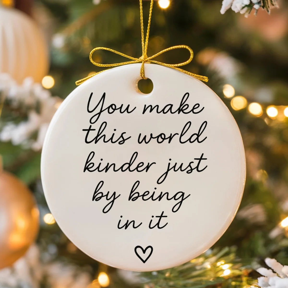 Alternate view of a round ceramic ornament with the visible You Make This World Kinder Just by Being in It message.