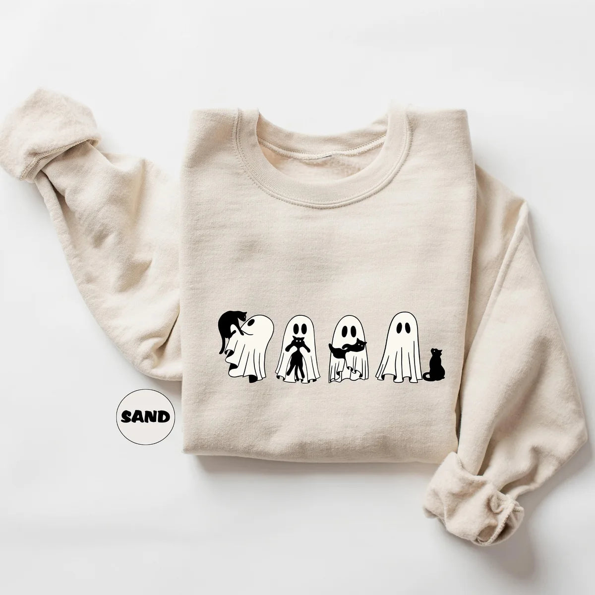 Sand crewneck sweatshirt with four ghosts and a black cat in a row, flat lay view.