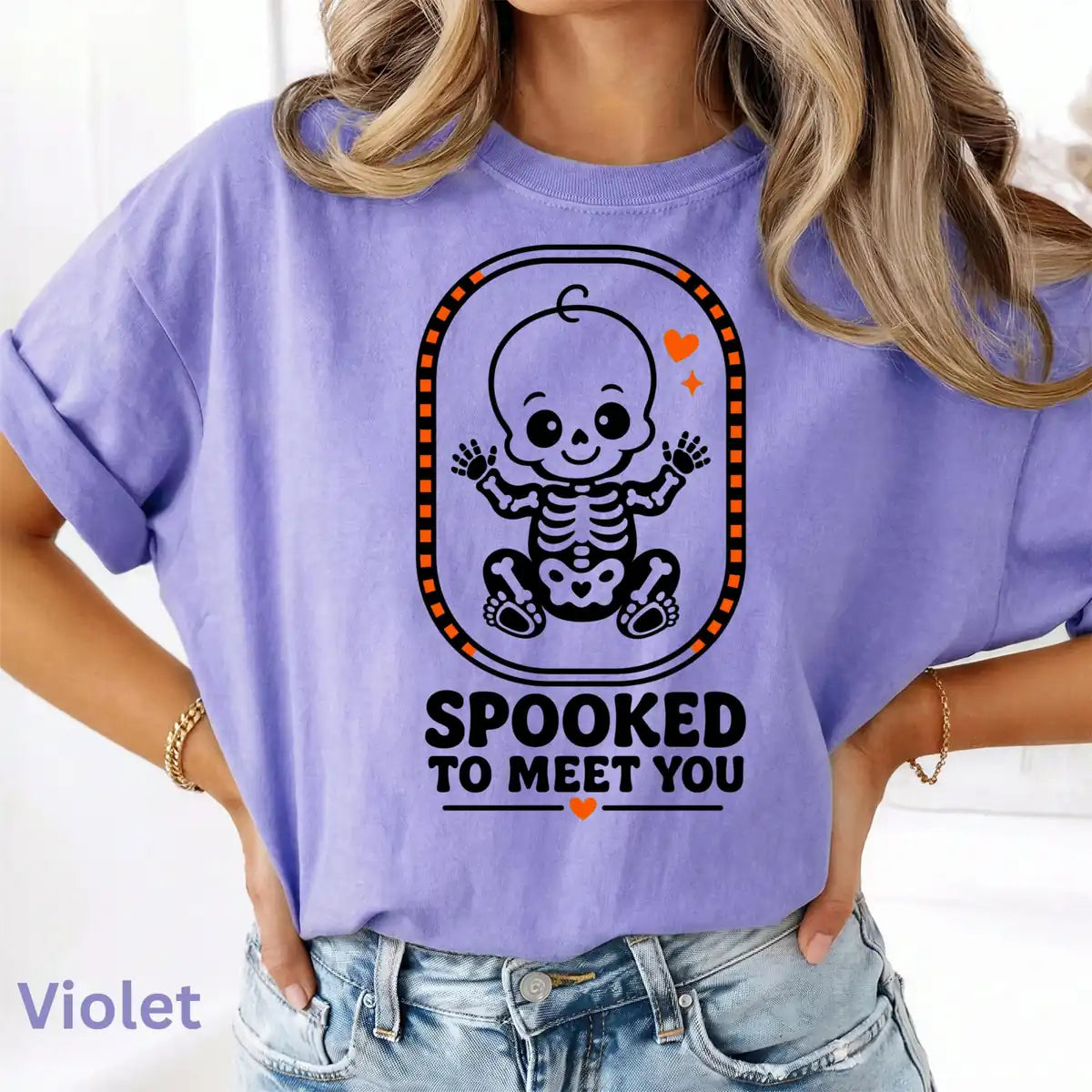 Comfort Colors T-shirt in Violet worn by model featuring Spooked To Meet You skeleton baby graphic