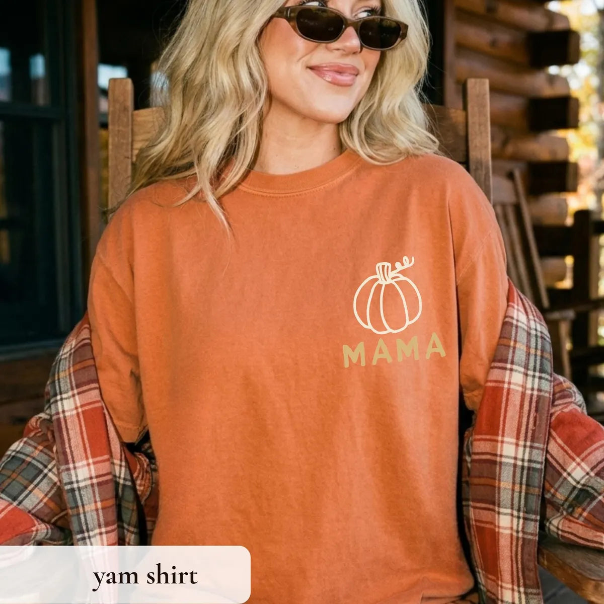 Woman in a Yam orange Comfort Colors tee and sunglasses with a pale pumpkin and MAMA on the chest, plaid wrap on her arms