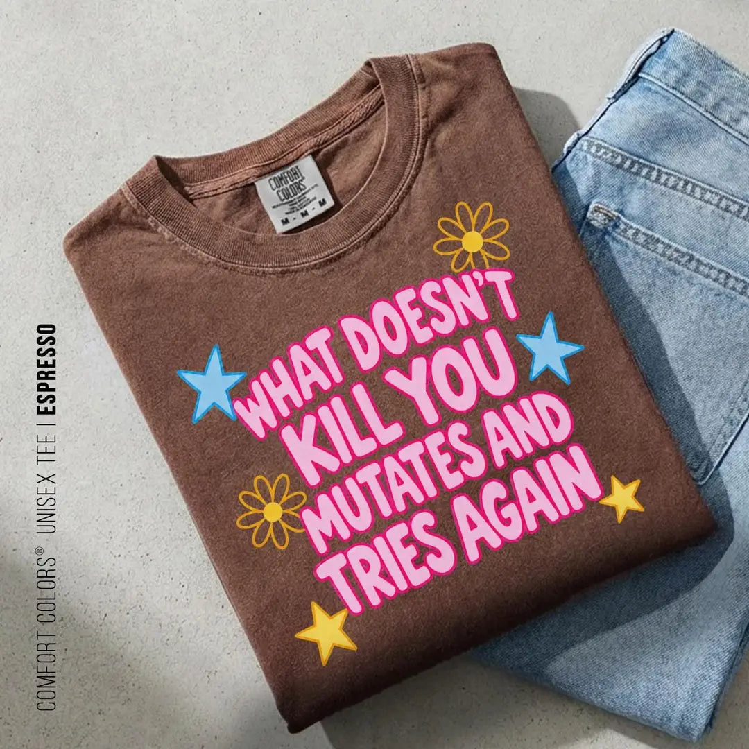 Folded Espresso brown Comfort Colors tee on blue jeans with pink mutates and tries again text and a yellow daisy