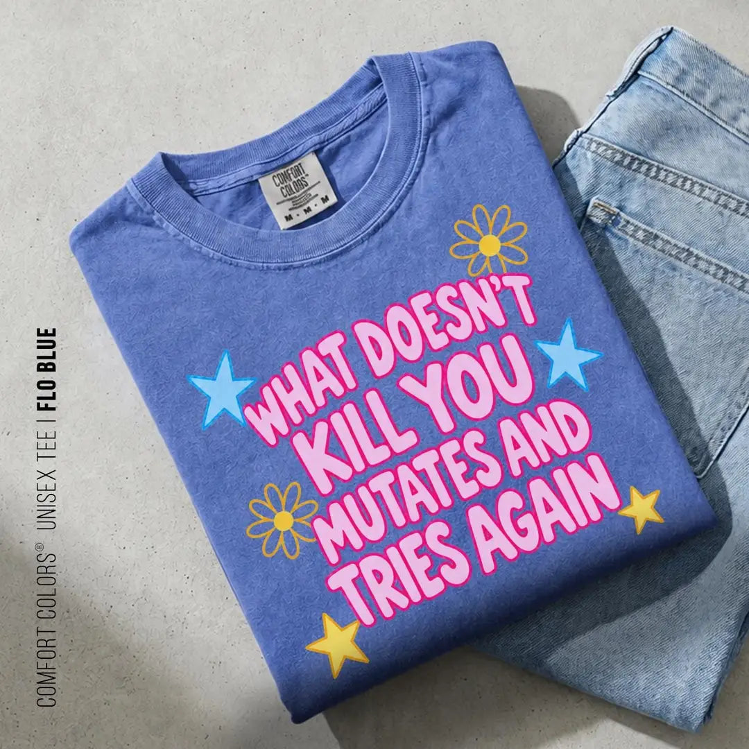 Folded Flo Blue Comfort Colors tee on blue jeans with pink bubble mutates and tries again lettering and yellow stars
