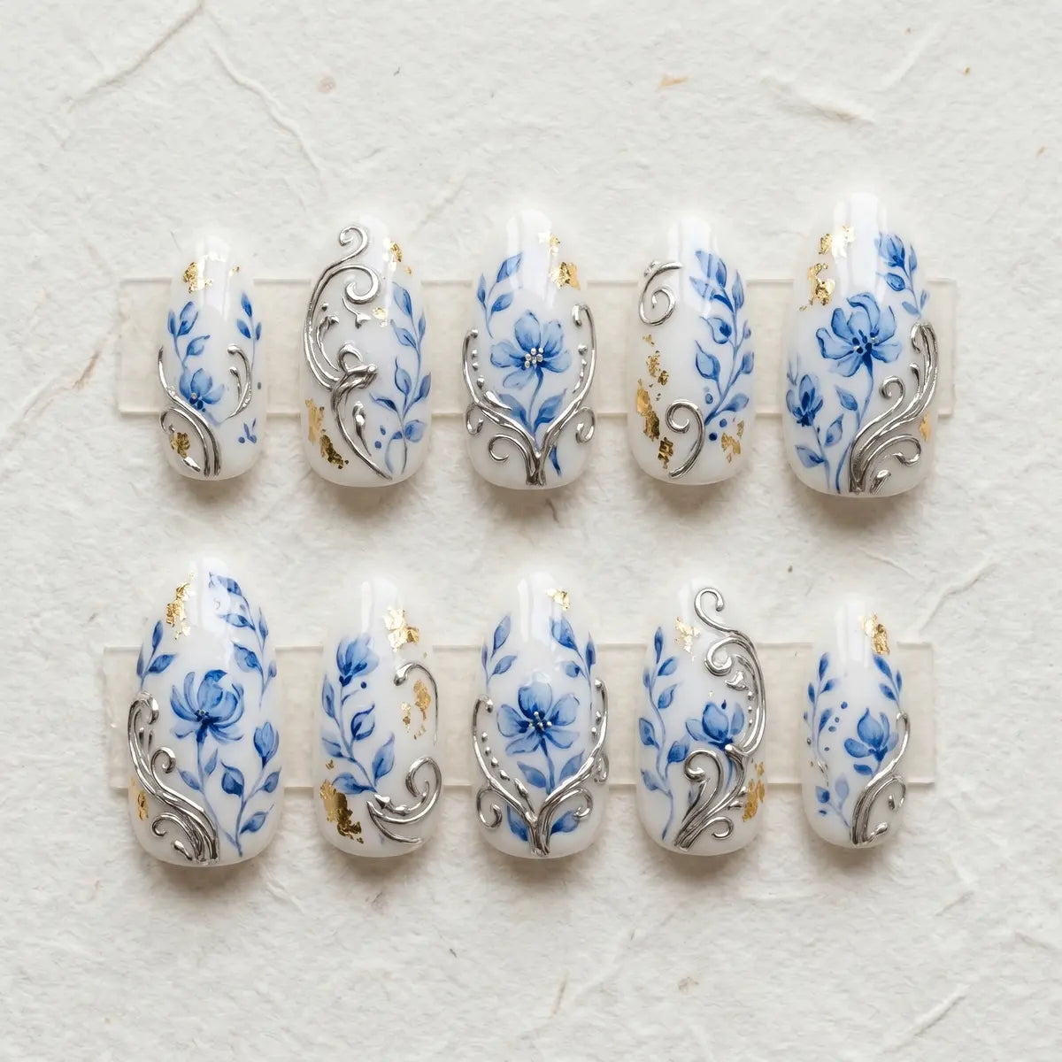 white blue hand painted almond press on nails gold foil flower silver swirl mockup 01